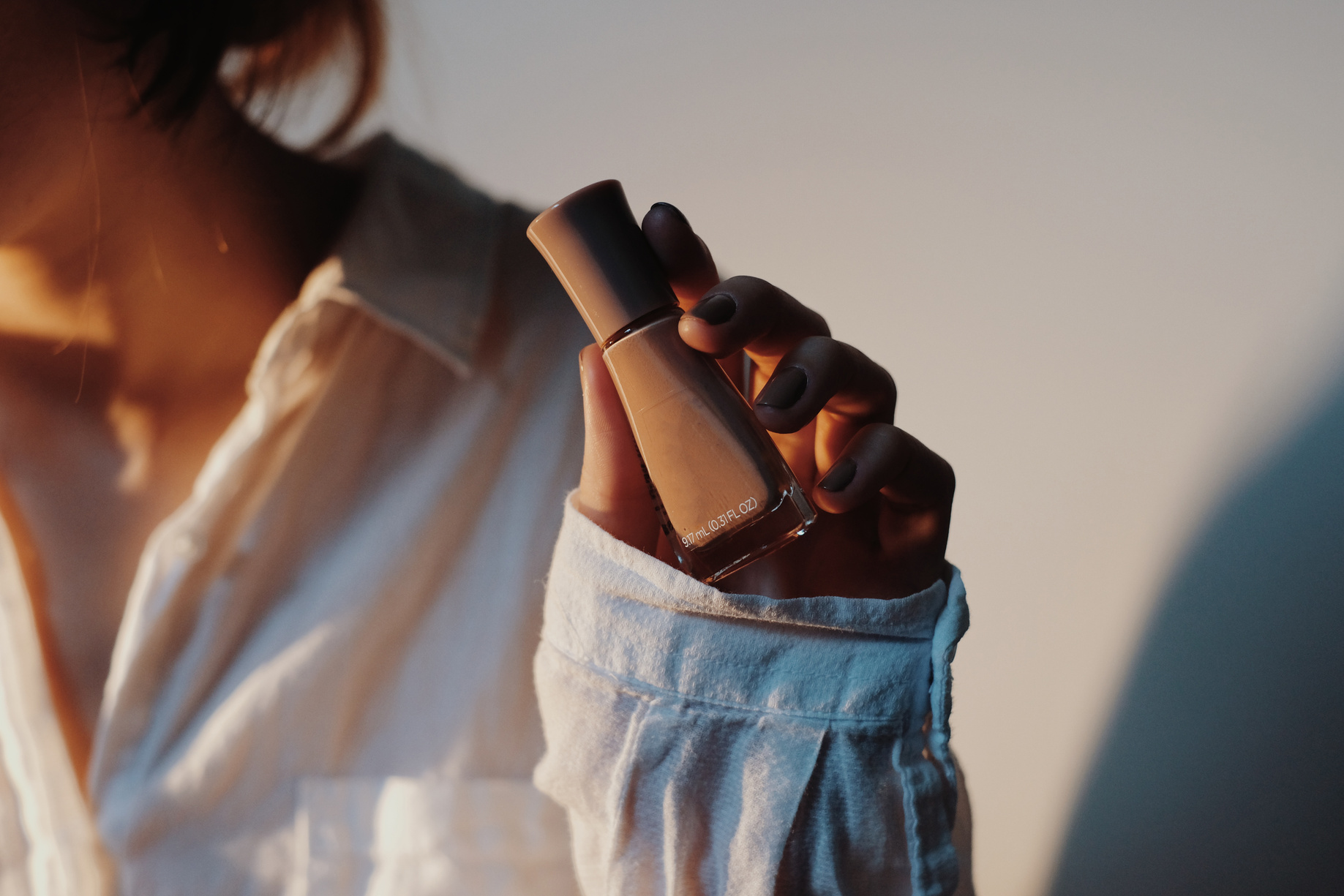 Woman holding bottle of nail polish